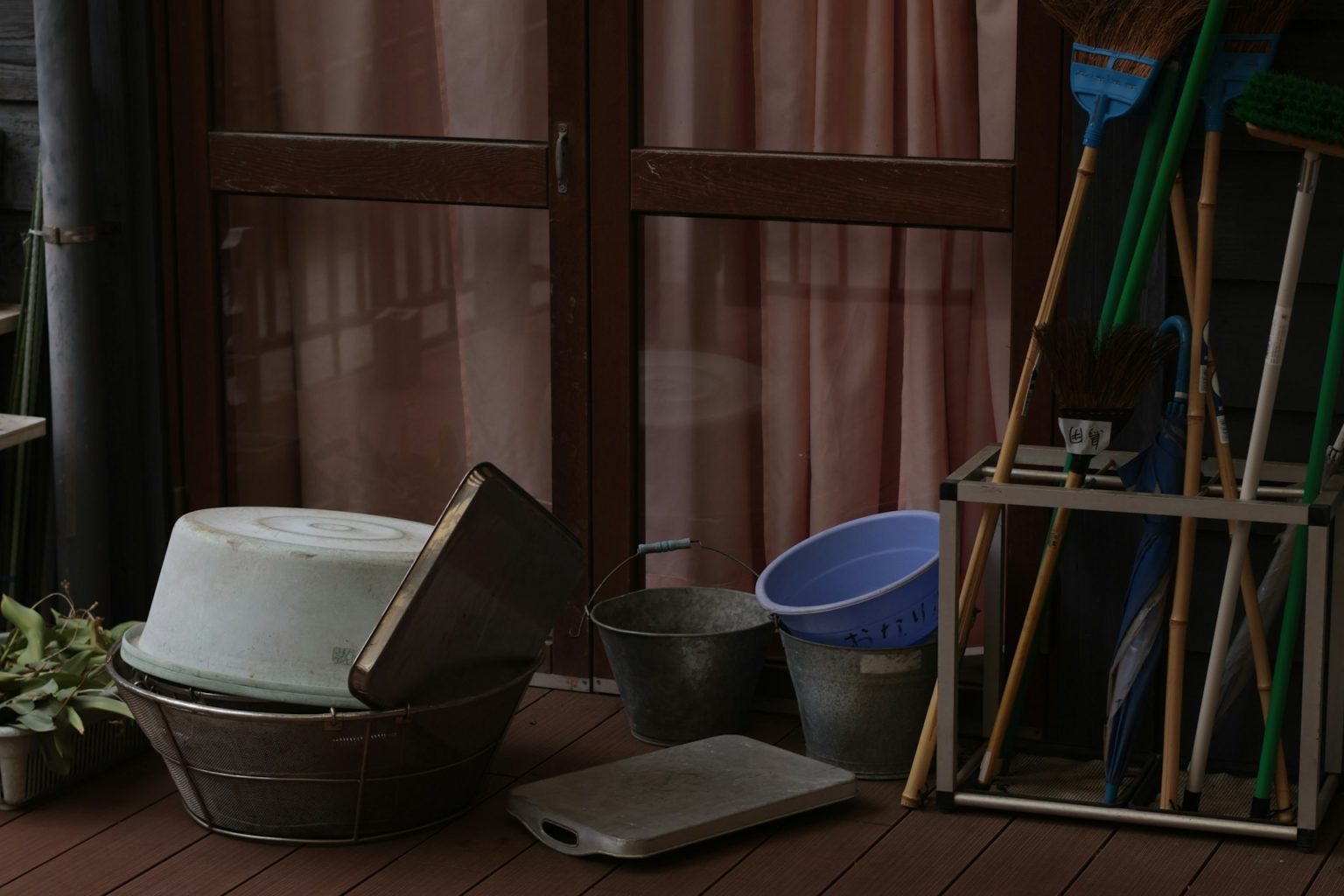 縁側に並ぶほうきとバケツ、たらいなどの掃除道具