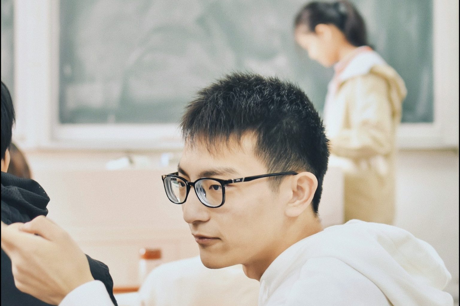 生徒の話を聞く眼鏡の講師