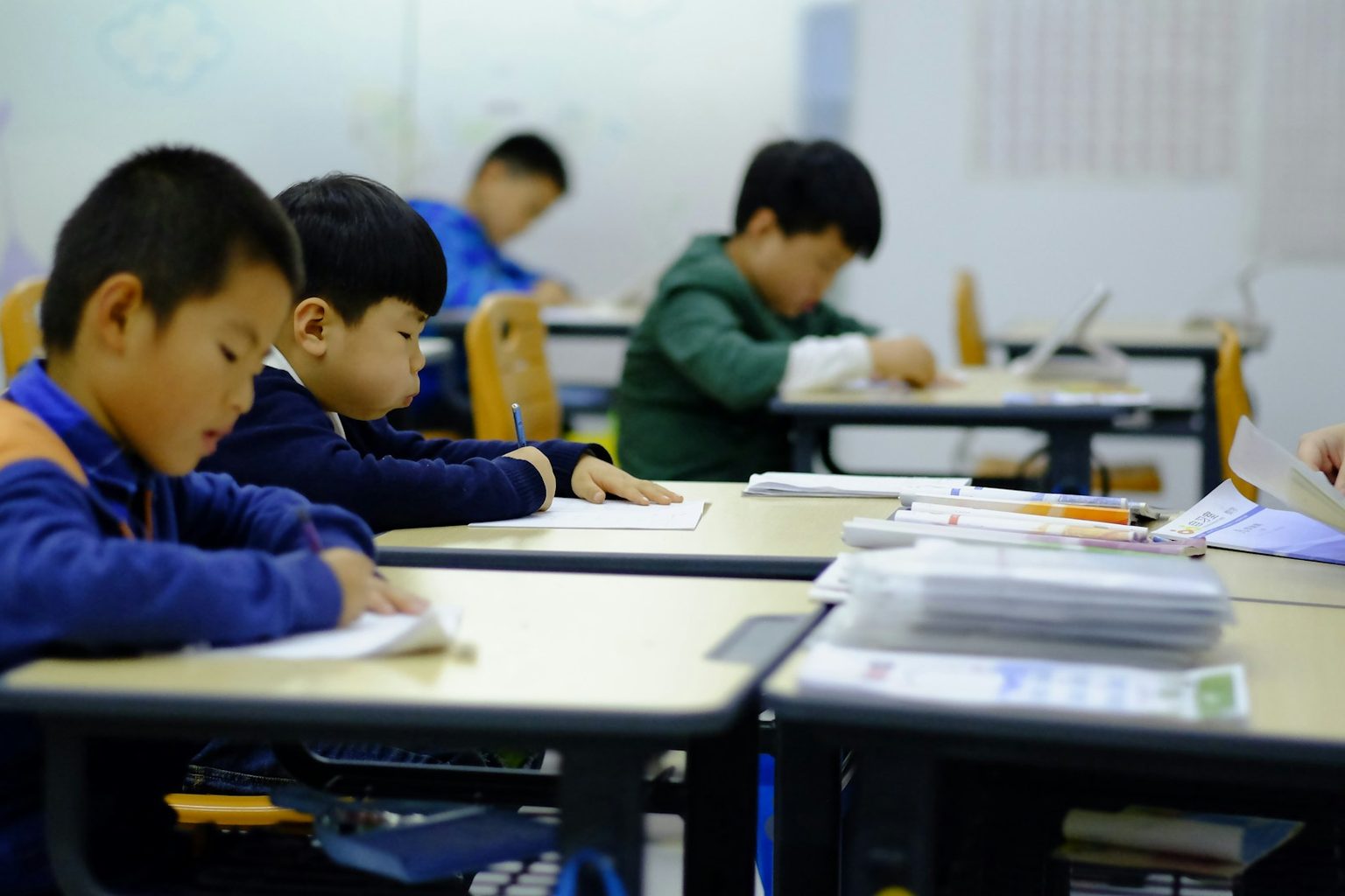 机に向かって問題を解く子どもたち