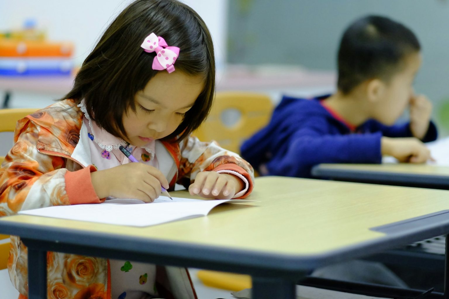 並んだ机で書き取りをする子どもたち