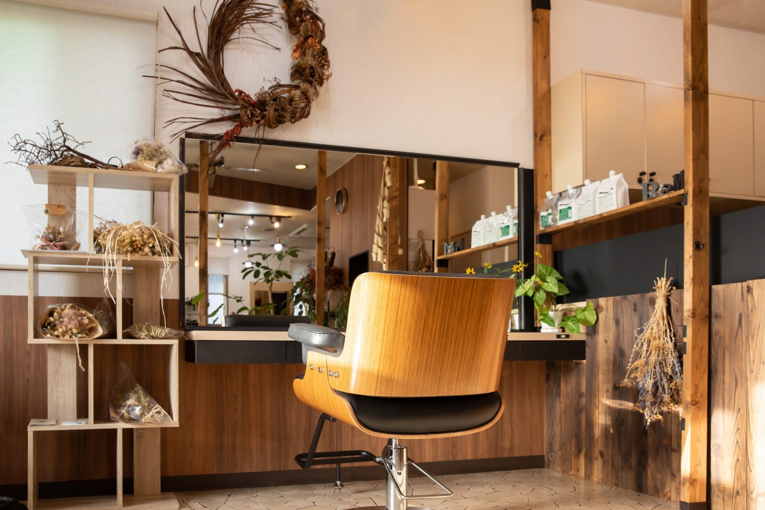 木の棚と鏡のある、落ち着いた美容室の店内