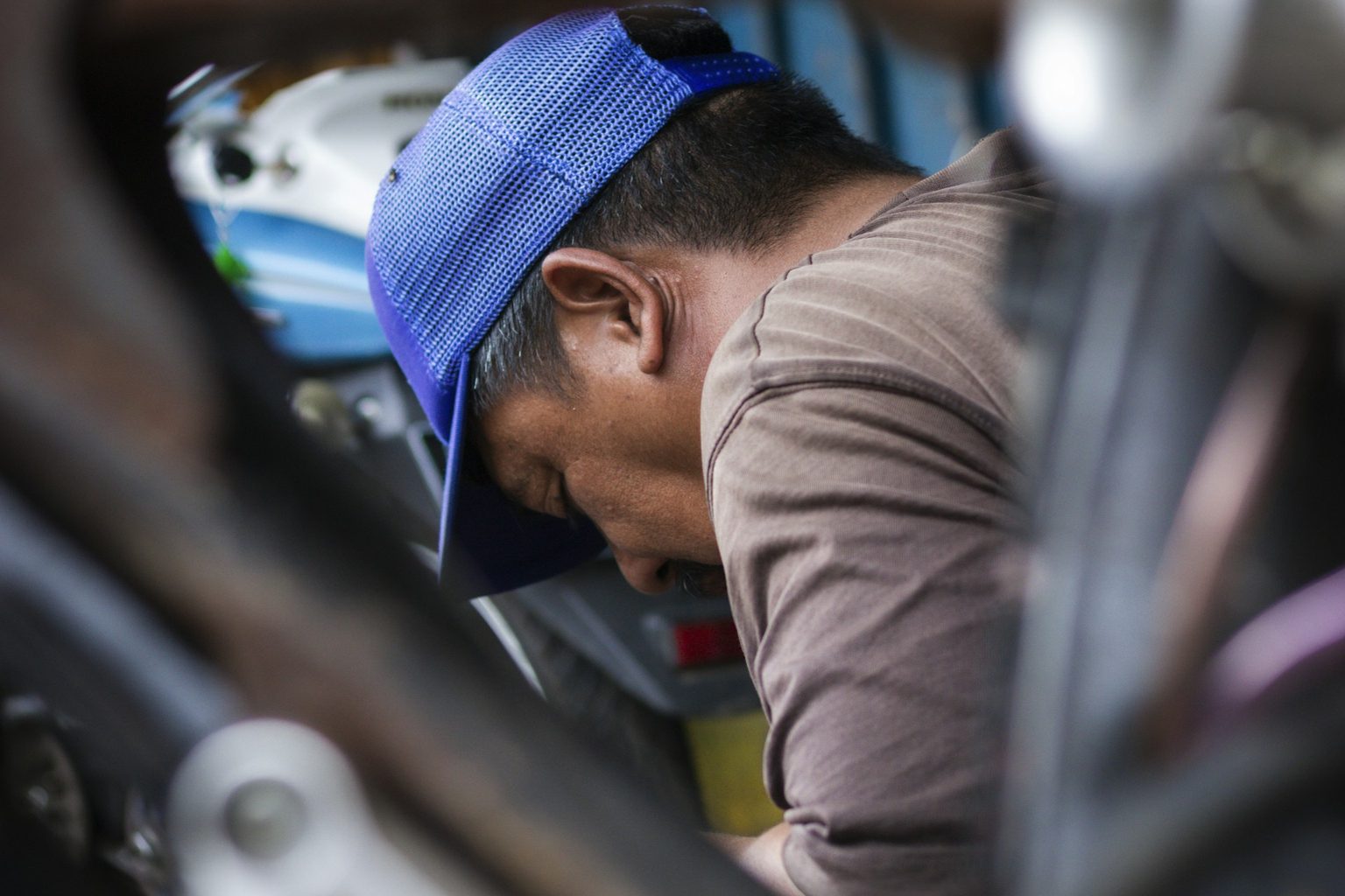 車の下をのぞきこむ整備士