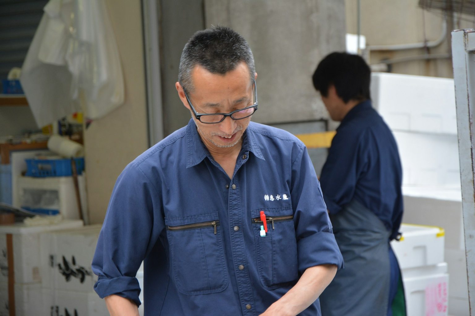 作業着姿で部品を確かめる社員