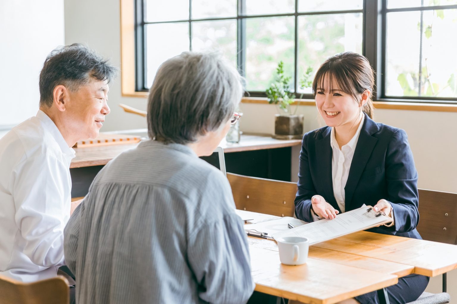 テーブルをはさんで相談を受ける担当者と、年配の夫婦