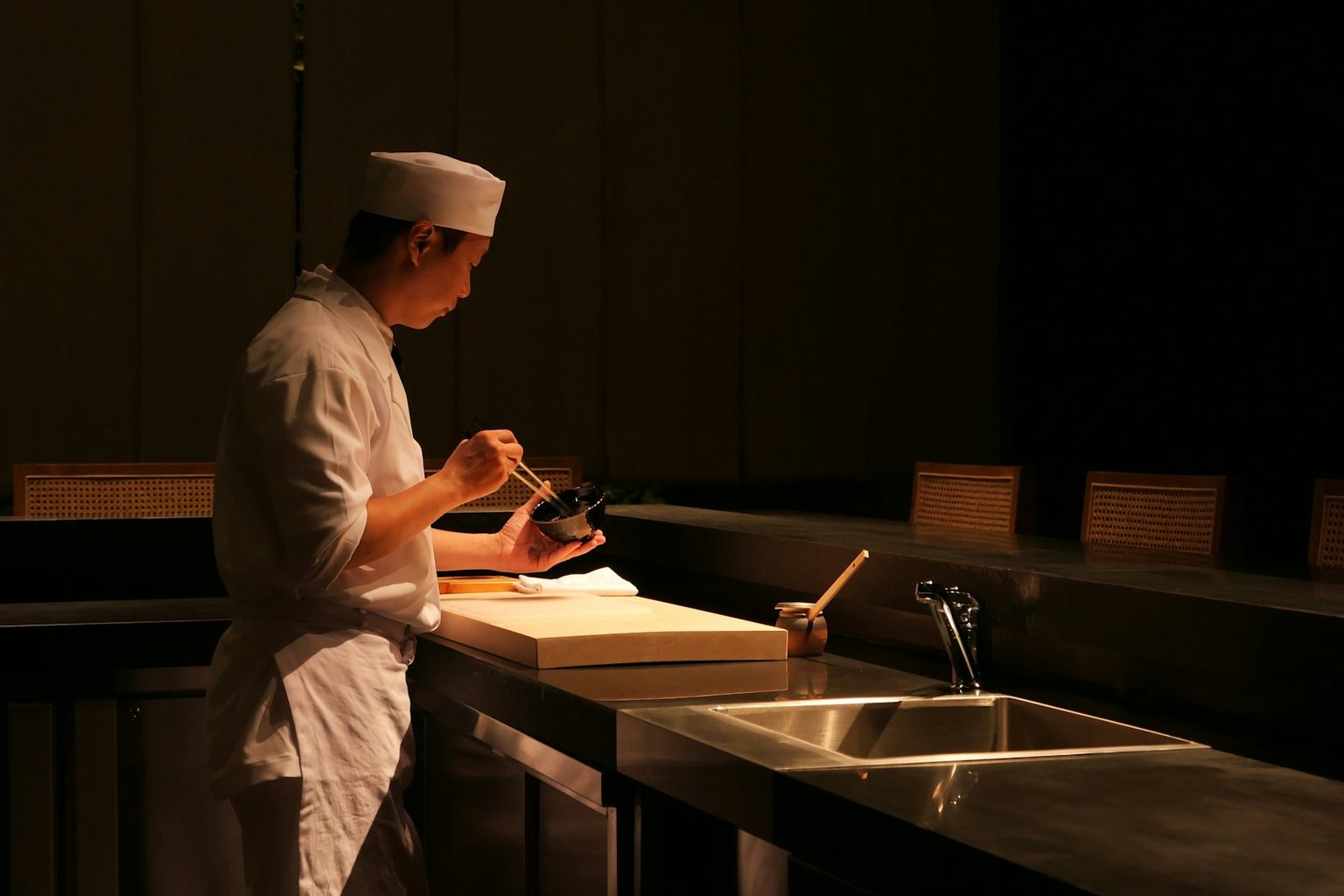 薄暗い厨房で仕込みをする料理人
