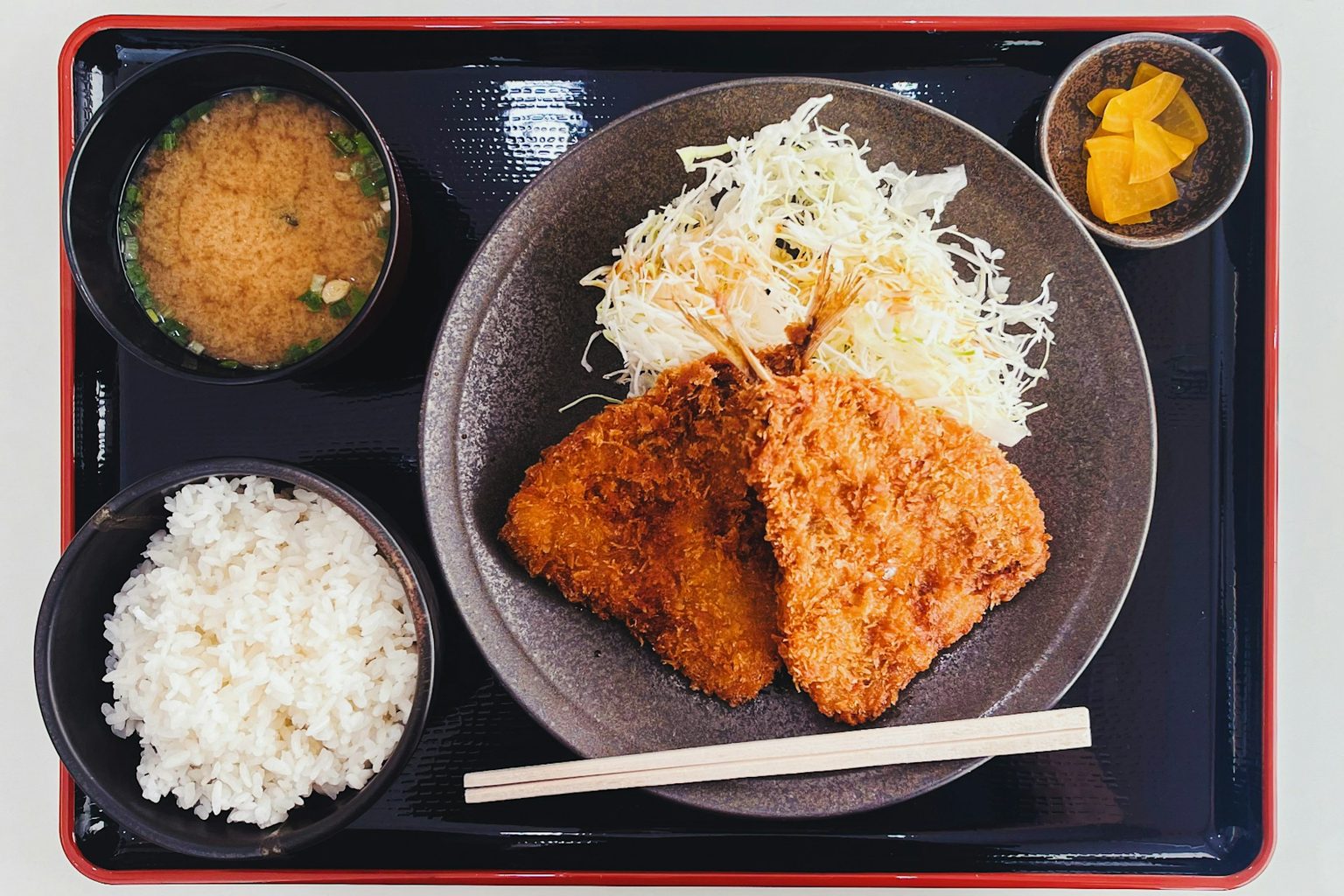 ごはんと味噌汁、小鉢がのったとんかつ定食