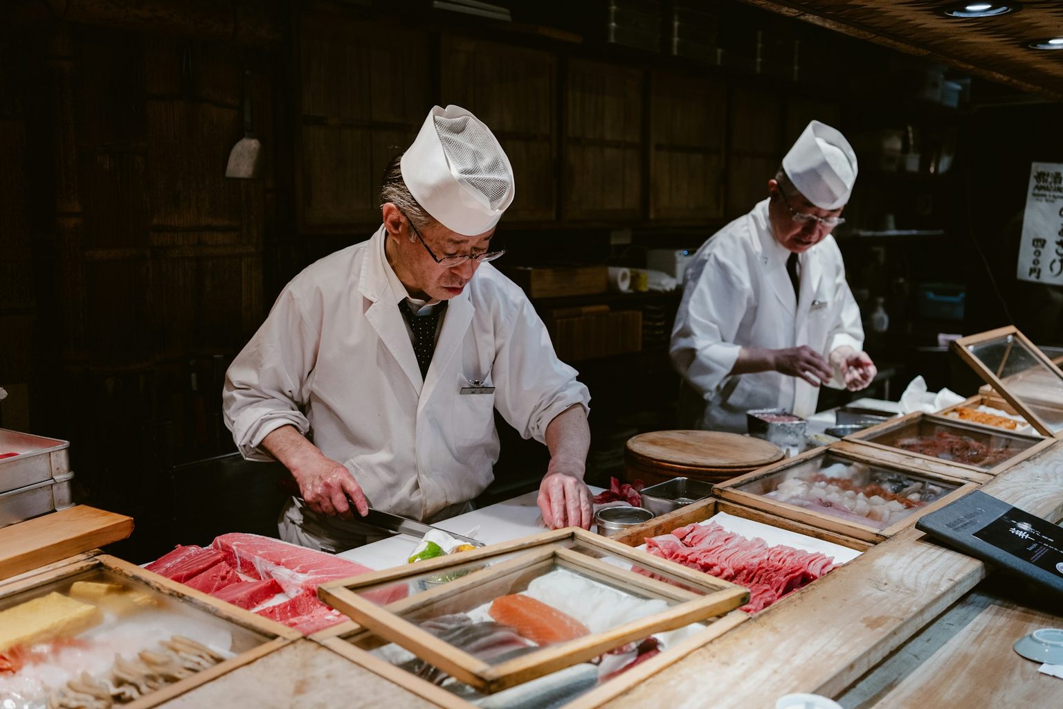 板場で並んで仕込みをする二人の料理人