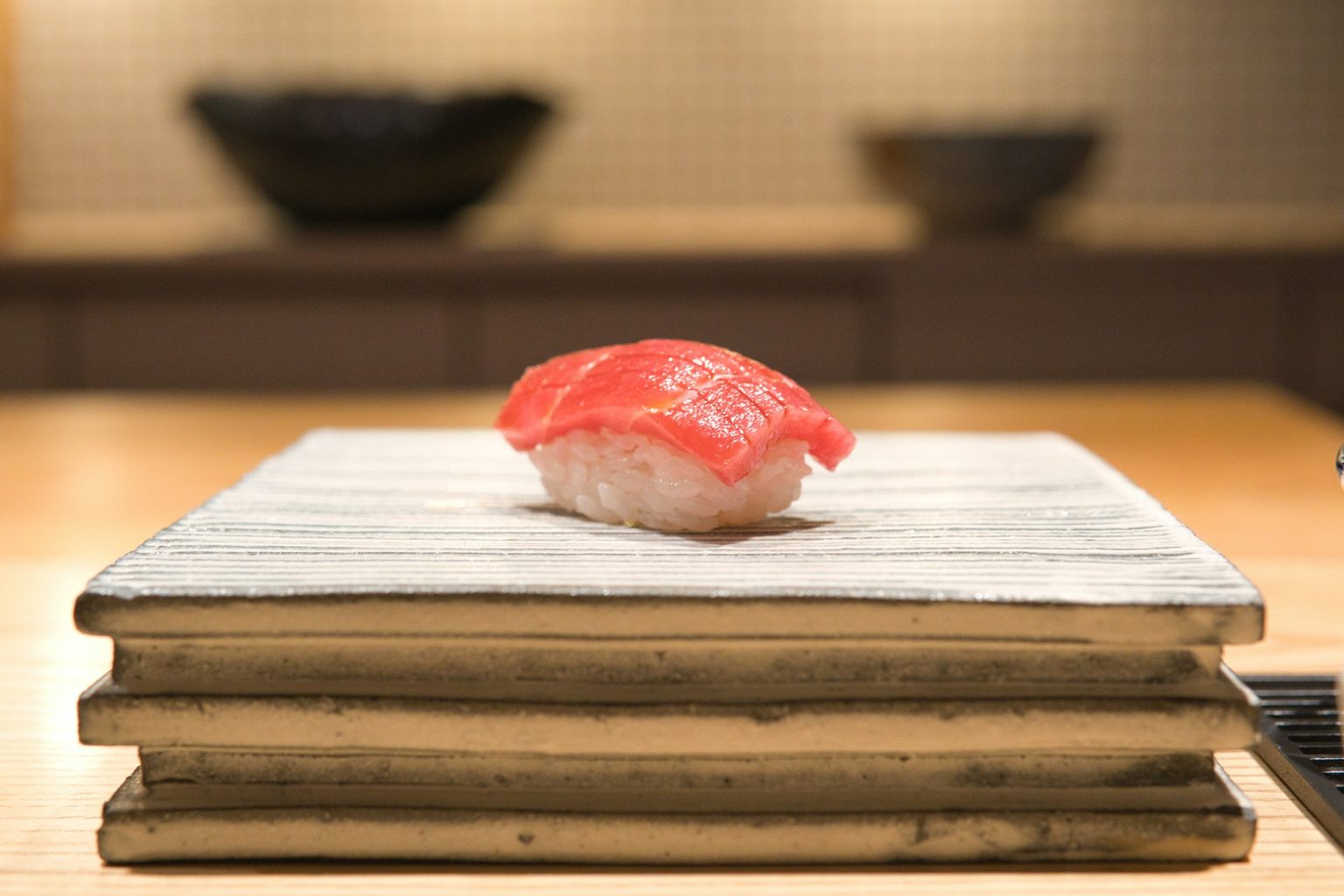 木の板にのせた、ひと貫のまぐろのにぎり