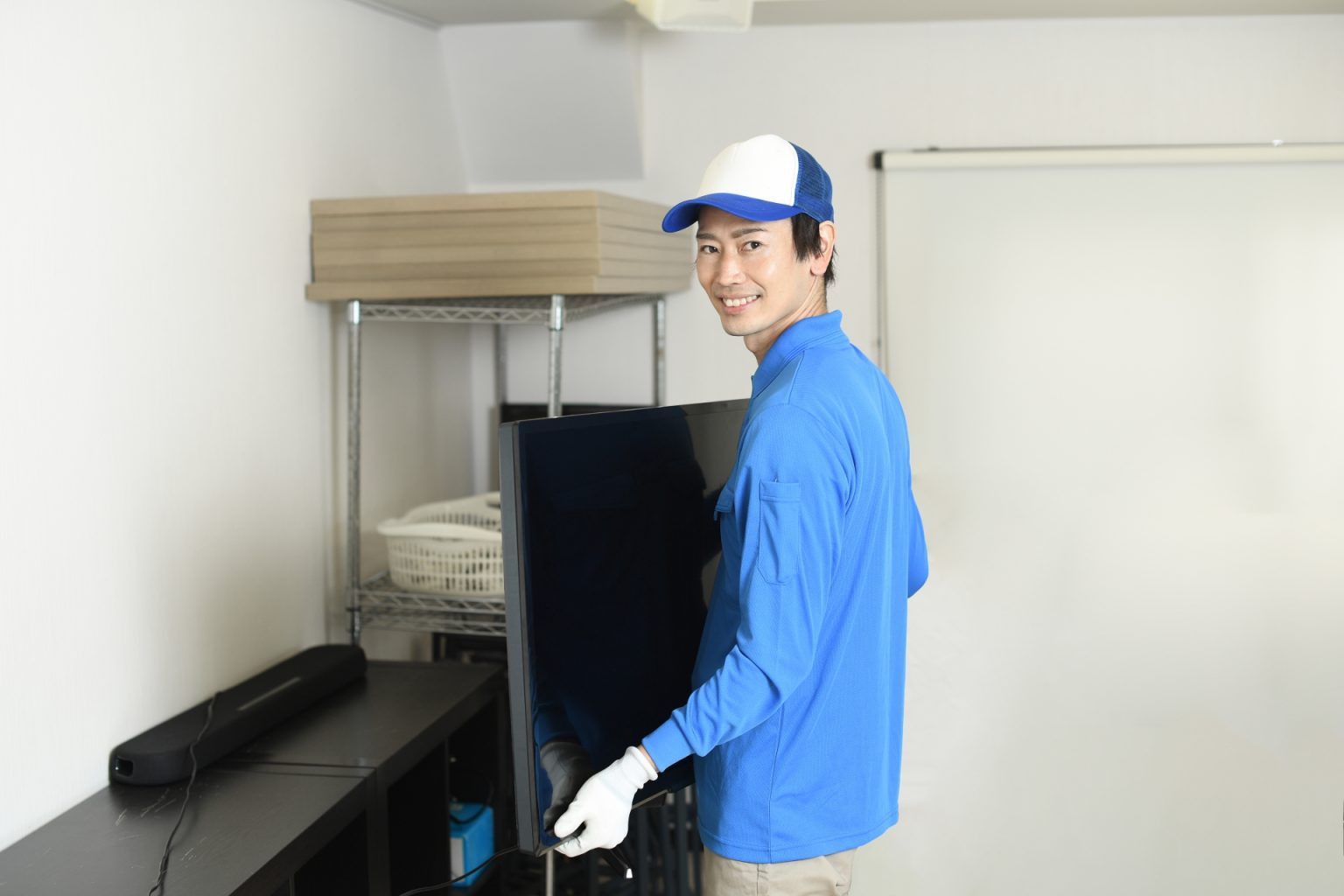 テレビを運び出すスタッフ