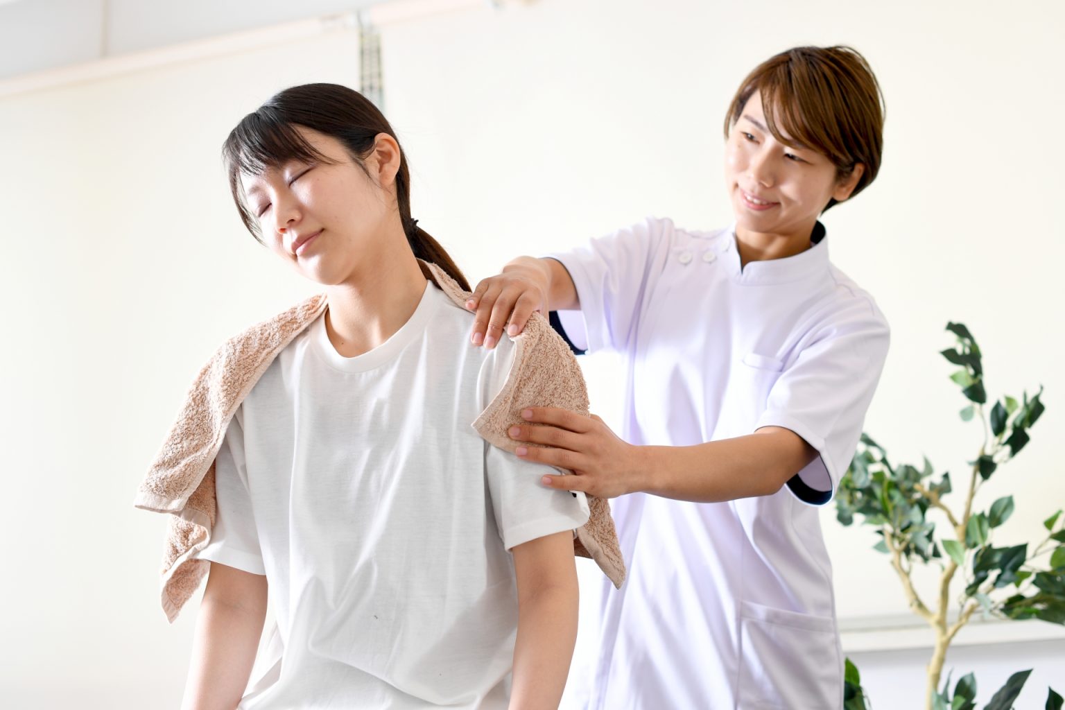 女性の肩をほぐしているセラピスト